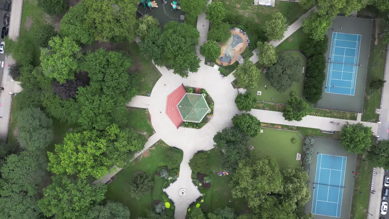 High-angle top-down view of a park in Jersey City featuring symmetrical paths, green spaces, and city layout, perfect for urban design, travel, lifestyle, or real estate visuals