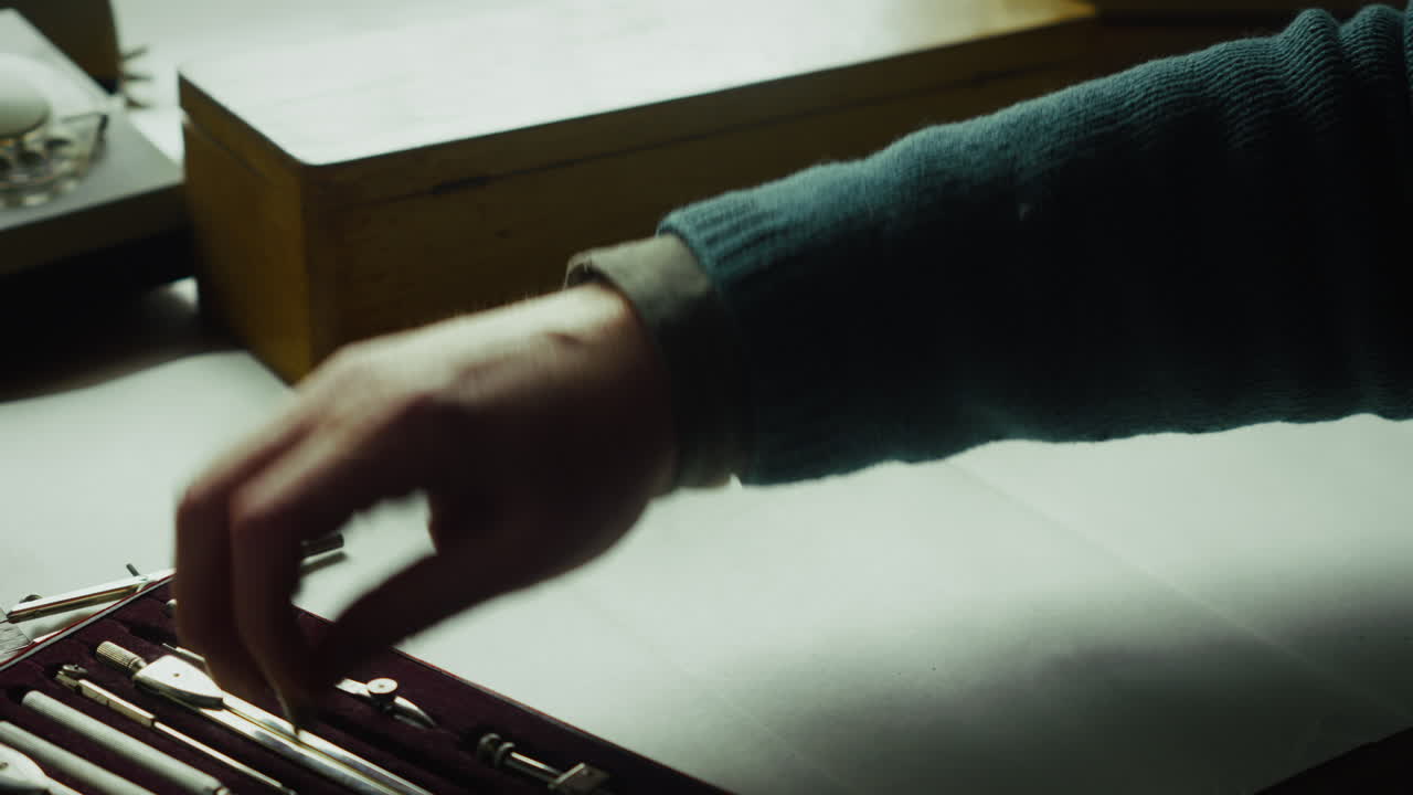 Close-up of a designer carefully drawing a circle with a compass, emphasizing precision, planning, and analytical thinking in technical or creative work