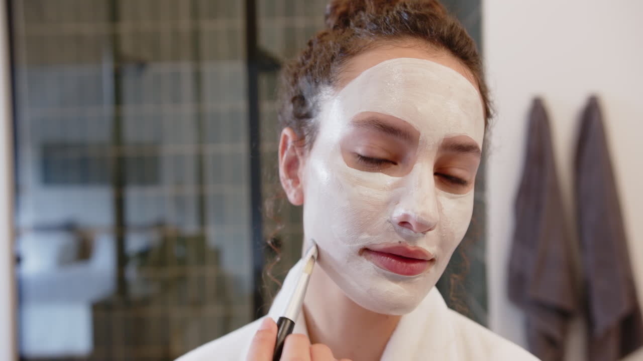 Applying facial mask, woman enjoying self-care routine in home setting