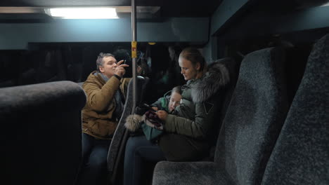 mom and son using mobile in the bus father taking video of them