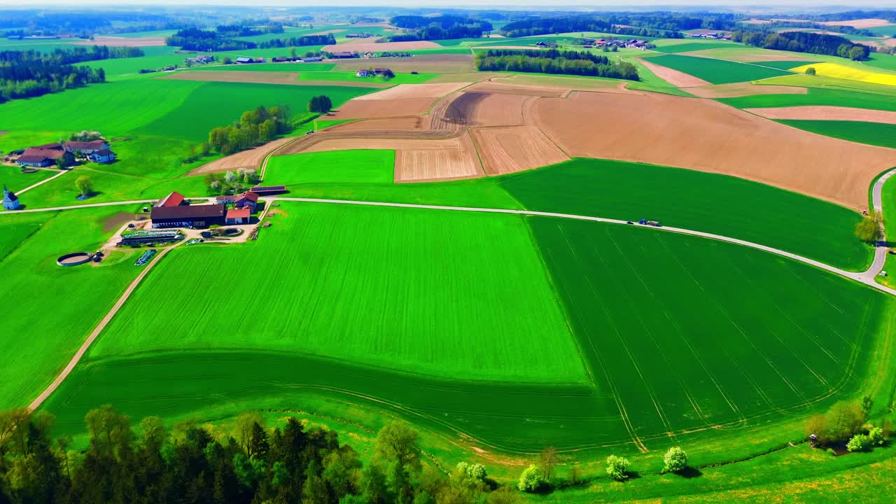 Vista aerea di una vasta area agricola con campi verdi e case rurali