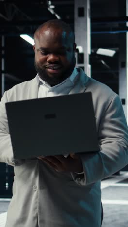 Vertical video Data center admin coding, writing script on laptop, identifying bottlenecks