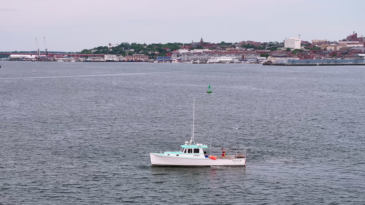 Aerial rotating view of fisherman aboard fishing boat in Portland harbor, Maine