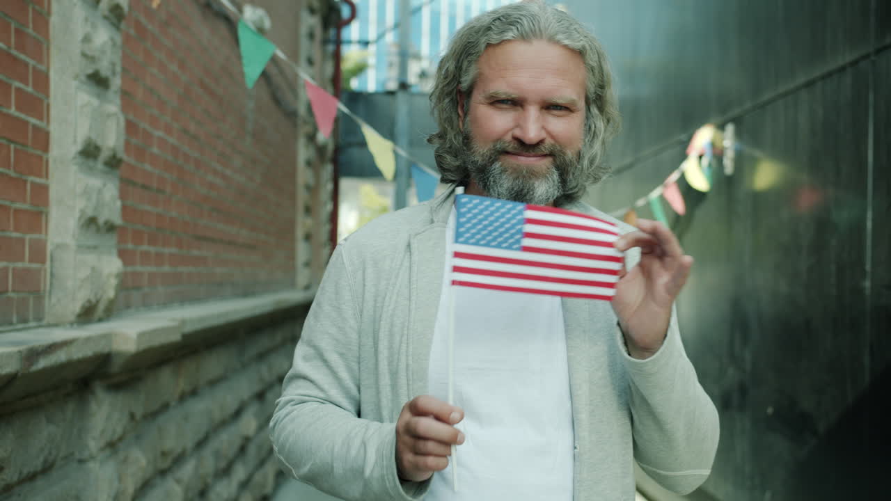 Man Holding American Flag in City Street