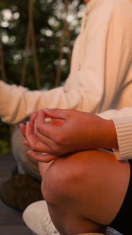 la gente medita sentada en el suelo de madera de cerca. los participantes del retiro de yoga contemplan pensamientos profundos en la naturaleza salvaje. terapia de pareja con prácticas mentales