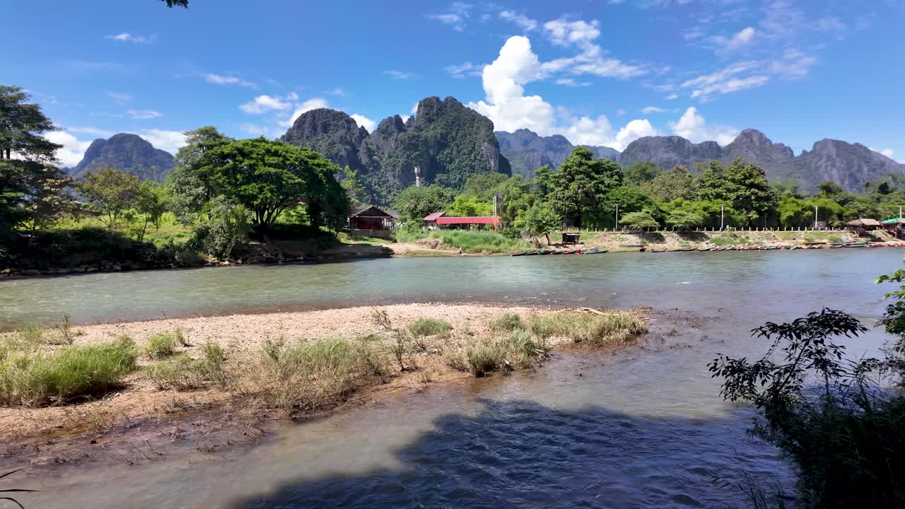 Nam Song River Scenery With Limestone Karst Mountains And Lush Greenery In Vang Vieng Laos Southeast Asia Under Blue Sky And White Clouds