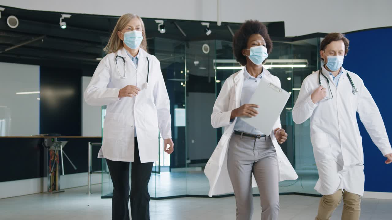 equipe médica multiétnica em máscara médica correndo no hospital para tratar uma situação urgente