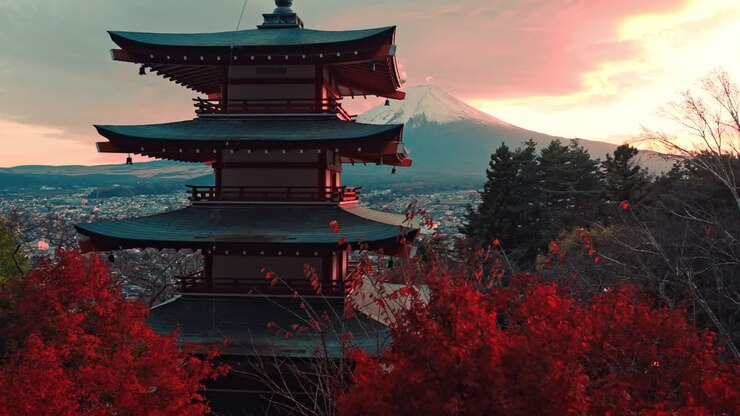 A cinematic shot of Chureito Pagoda bathed in the warm hues of sunset, surrounded by the vibrant red leaves of peak autumn.
