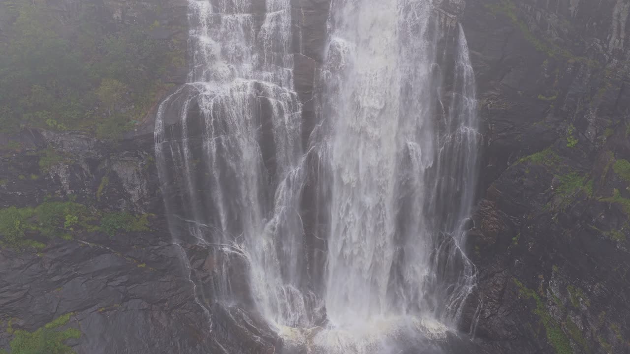Toma aérea cinematográfica de la cascada de Skjervefossen durante el clima tormentoso de Noruega