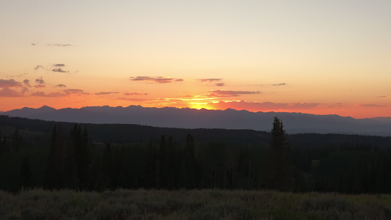 золотой горизонт над силуэтом горного пейзажа возле деревни во время захода солнца