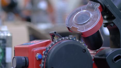 máquina automática de afilado de cadenas de sierra durante el trabajo en el taller - de cerca