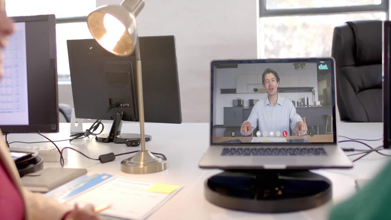Laptop with video call with caucasian businessman on screen