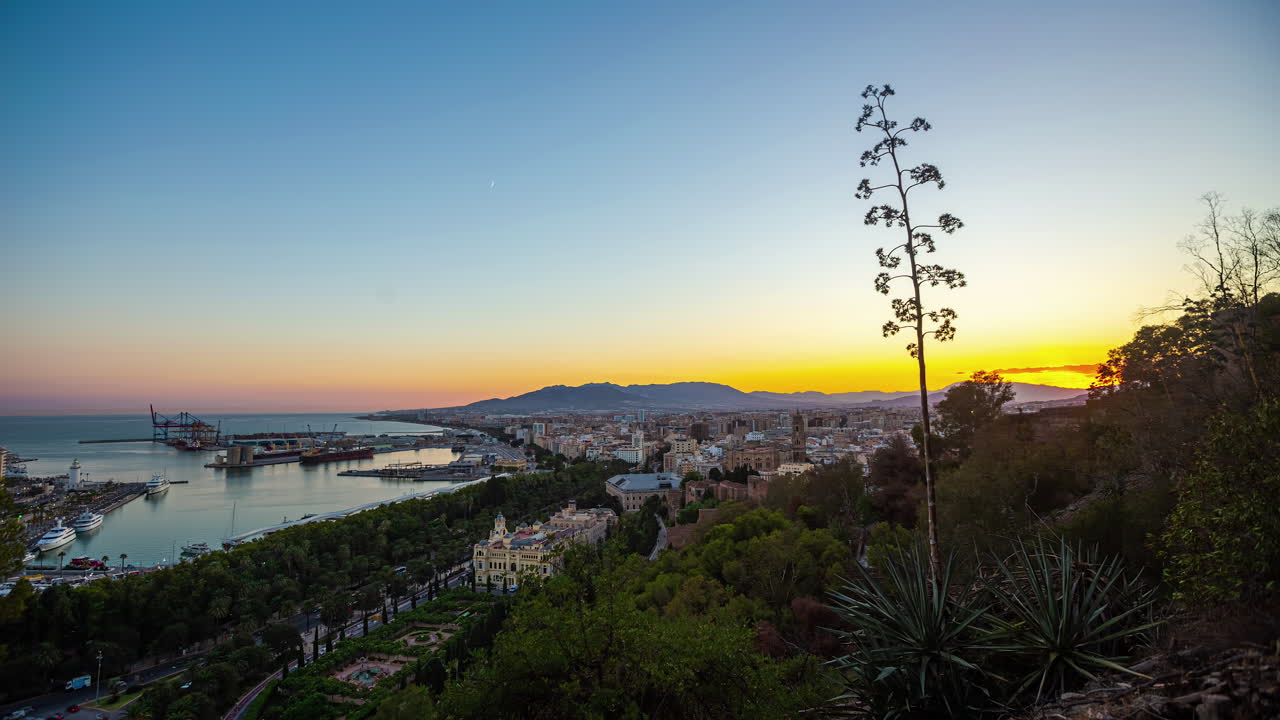 Timelapse Overlooking Puerto de Málaga, Capturing the City's Sunset with the Moon Setting Over the Horizon