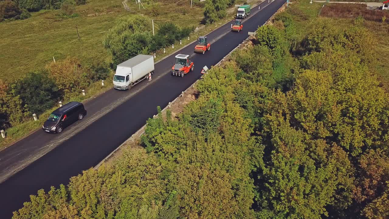 Aerial view on the new asphalt road under construction. Laying a new asphalt on the road.