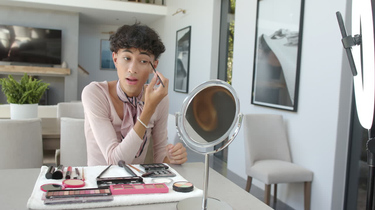 Applying makeup at home, non binary person using mirror and makeup tools