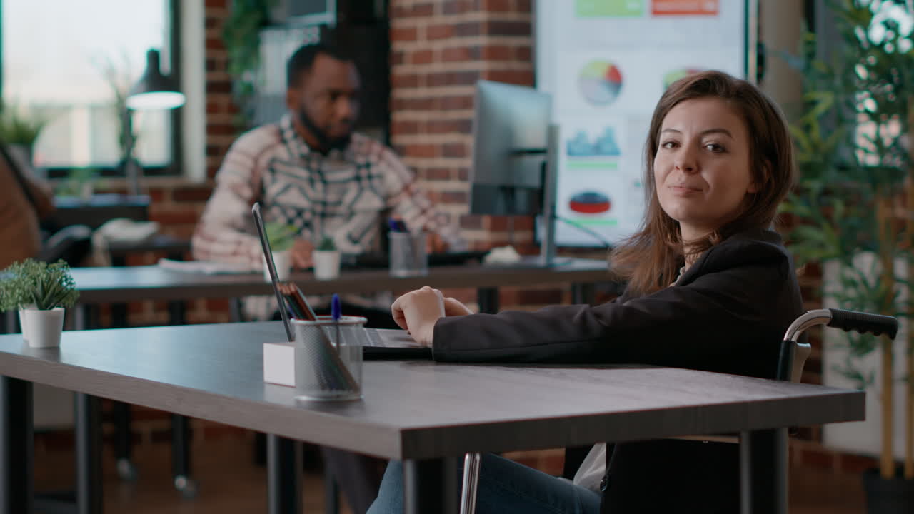 Portrait of young woman in wheelchair working on data analysis