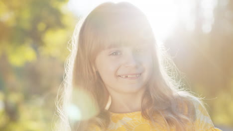 portrait of happy preteen child girl face smiling looking at camera good mood, satisfied on park