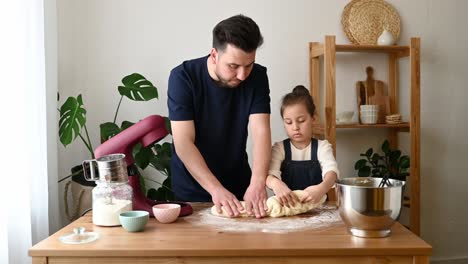 Father-And-Daughter-Kneading-Dough-On-Table