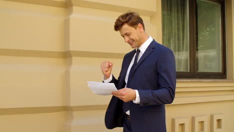 successful business man reading financial documents outdoor