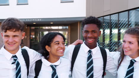 Portrait-Of-Smiling-Male-And-Female-High-School-Students-Wearing-Uniform-Outside-College-Building