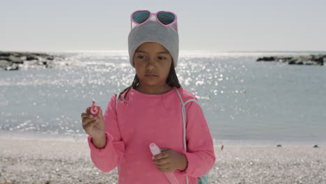 Porträt-Eines-Kleinen-Mädchens,-Das-Am-Strand-Seifenblasen-Bläst-Und-Rosa-Kleidung-Trägt