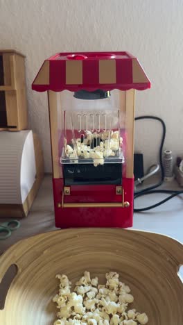 retro-style popcorn machine in a theater or cinema design, popping fresh popcorn. content related to movie nights, snacks, or vintage-inspired kitchen appliances with nostalgic vibe. vertical.