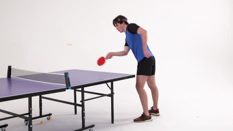 playing table tennis, man in blue shirt hitting ball on purple table