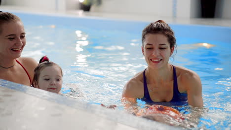 group of mums with their baby children at infant swimming class