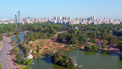 Luftaufnahmewagen-Im-See-Des-Rosengartens-Von-Palermo-An-Einem-Sonnigen-Tag,-Wohngebäude-Der-Stadt-Buenos-Aires-Im-Hintergrund,-Griechische-Brücke