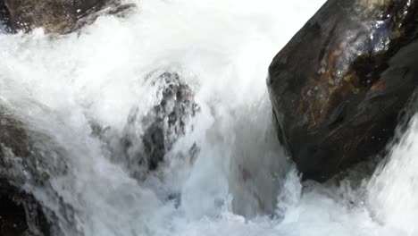 Water-cascades-over-rocks-in-mountain-river-stream,-60fps