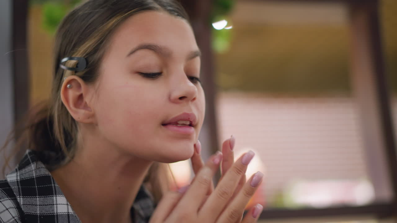 소녀는 차분한 표정으로 코와 을 부드럽게 마사지하며, 피부 관리 루틴에 초점을 맞추고, 클로즈업 은 부드러운 피부, 자기 관리 과정, 그리고 편안한 환경에서 미용 요법을 강조합니다.