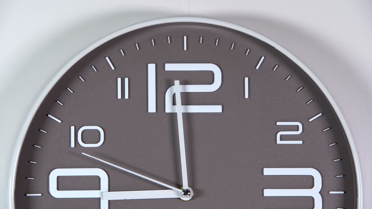 reloj de pared sobre un fondo gris. las nueve.