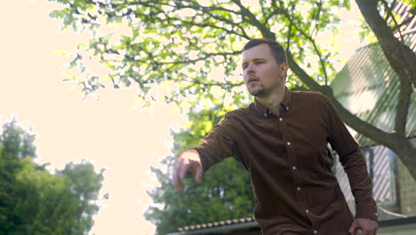 bottom view of caucasian young man throwing a petanque ball in the park on a sunny day