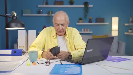 Home-office-worker-old-man-showing-his-empty-wallet-to-the-camera.