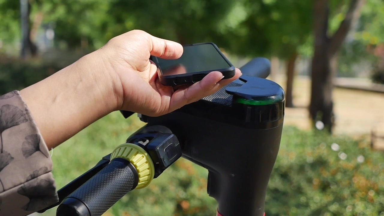 Pessoa Desbloqueando Patinete Elétrico com Aplicativo de Smartphone