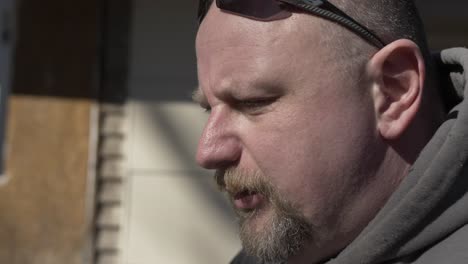 a closeup of a man standing outside talking in slow motion