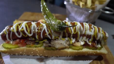 Toma-De-Establecimiento-Lento-De-Un-Hot-Dog-Cubierto-De-Mayonesa-Y-Mostaza-Listo-Para-Servir.