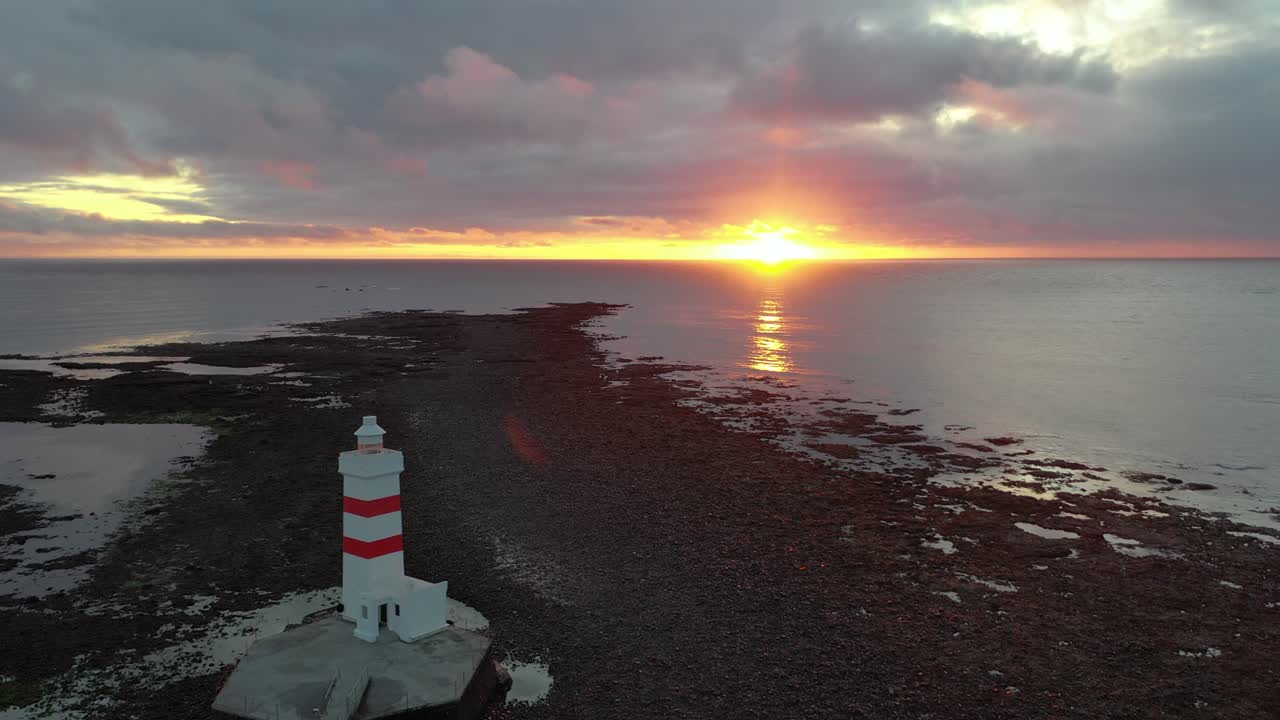Tourist destination in Iceland with lighthouse and stunning sunset