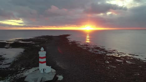 tourist destination in iceland with lighthouse and stunning sunset