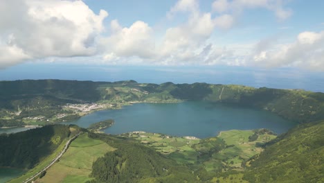 beautiful drone footage of the volcanic mountain lakes of the azores islands and surrounding lush green forests, fields and cliffs and the atlantic ocean