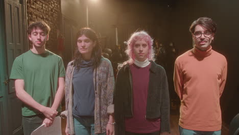 group of young actors posing on theater stage at rehearsal