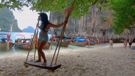 slow motion | smiling girl in bikini on beach swing in thailand