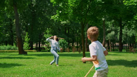 active boy playing badminton with mother back view. sport in family life concept