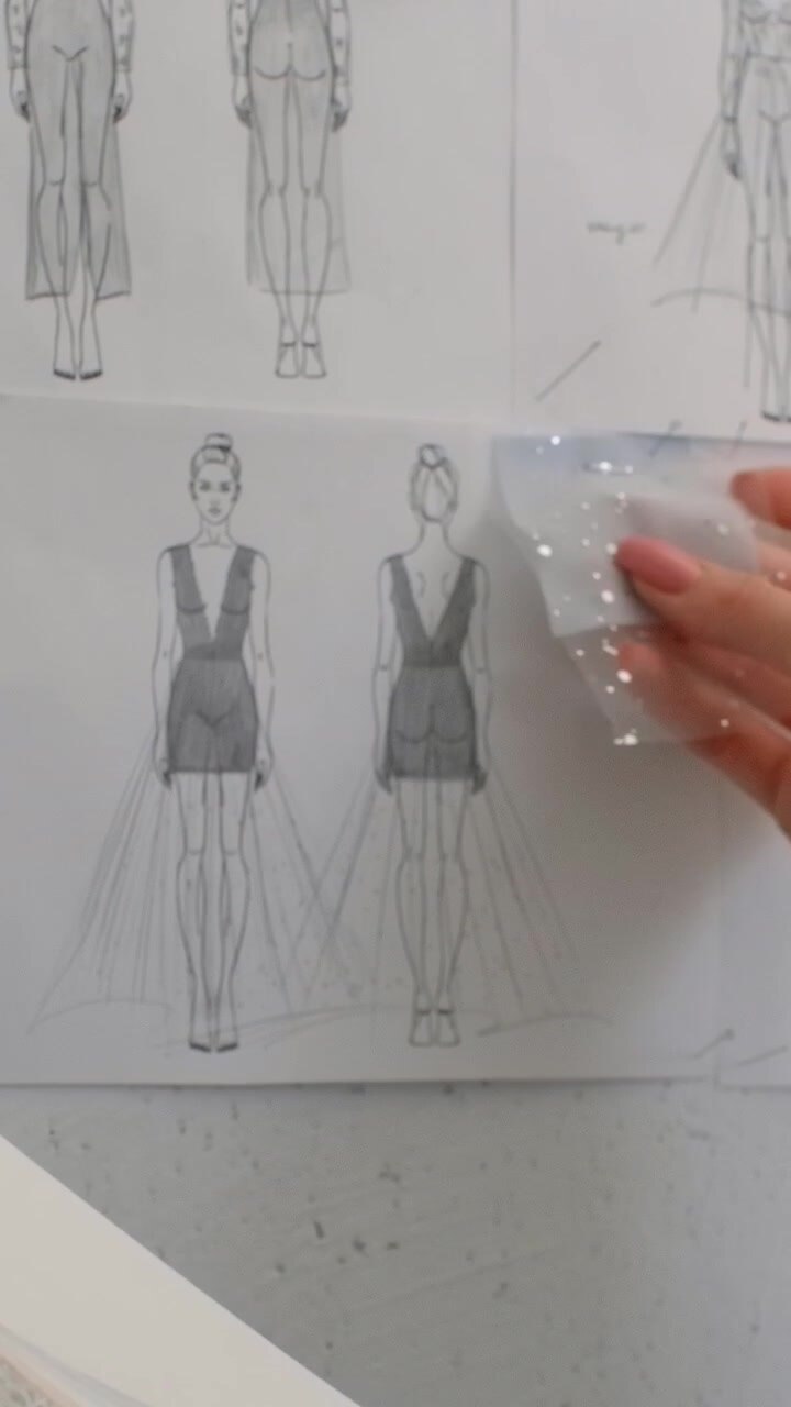Fashion designer che confronta un campione di tessuto con lo schizzo di un abito