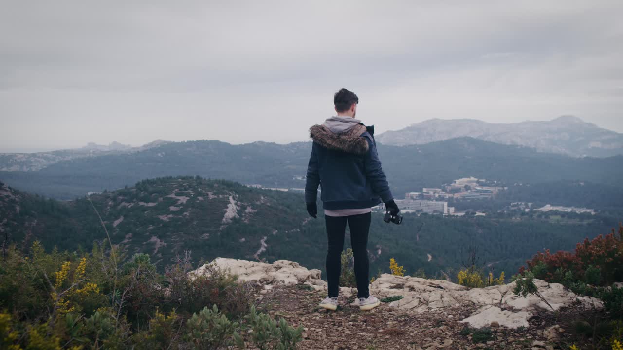 벼랑 끝에 있는 남자가 프로방스 산의 파노라마를 바라본다