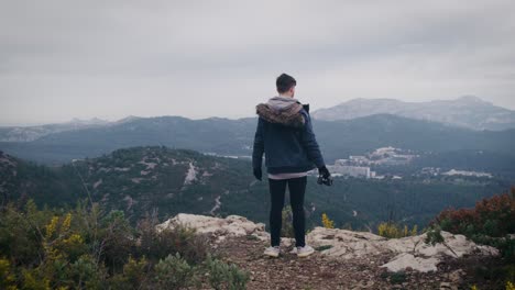 man at the edge of precipice looks at mountain panorama of provence