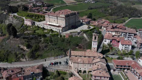 Cinematic-aerial-of-old-church-and-castle-in-a-small-Italian-town