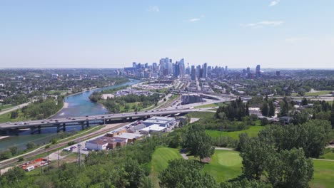 flying over shaganappi golf course with the bow river and the vista downtown of calgary alberta canada coming more into view