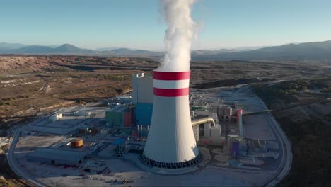 drone smoke from a coal fired power station tracking chimney rural tilt down sunset