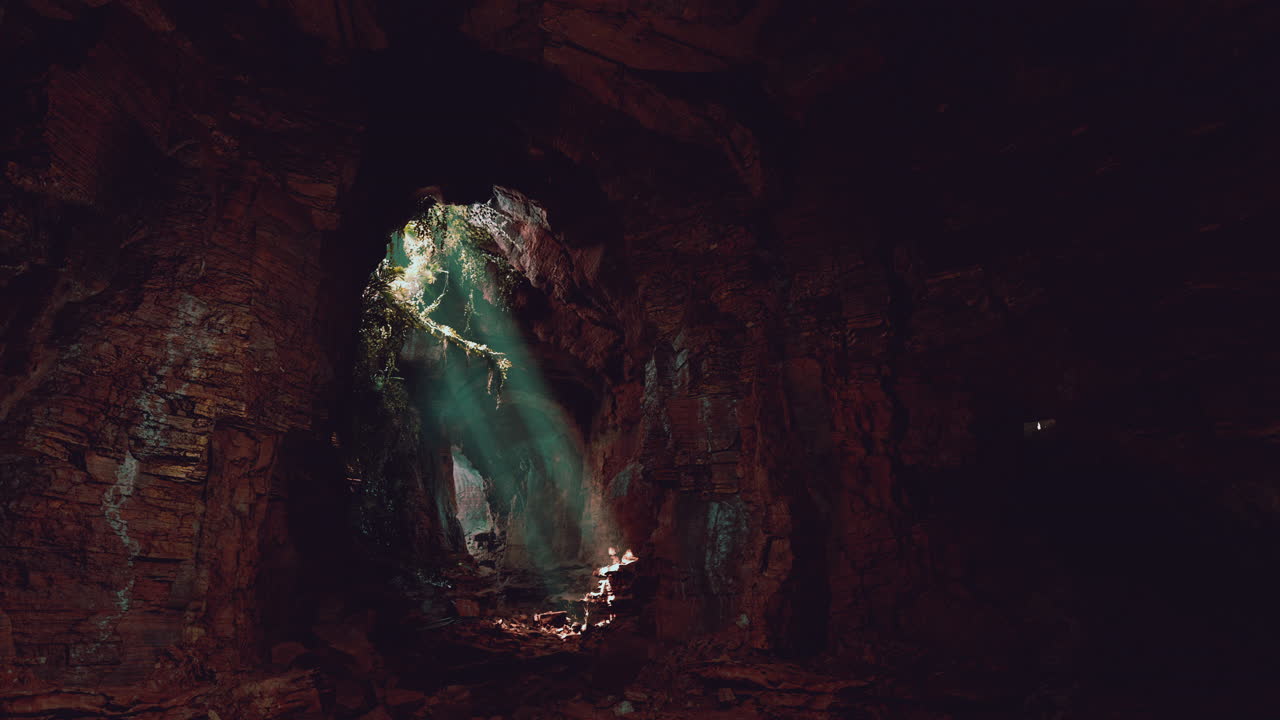 explorando una cueva oscura y misteriosa: los rayos de luz solar iluminan el camino